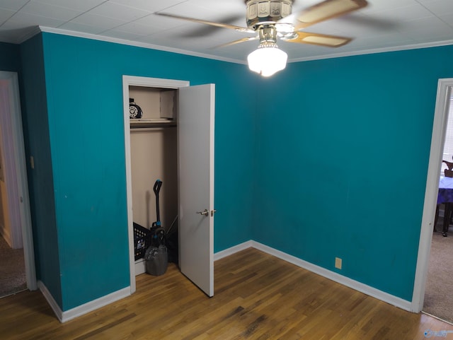 unfurnished bedroom featuring crown molding, ceiling fan, hardwood / wood-style floors, and a closet