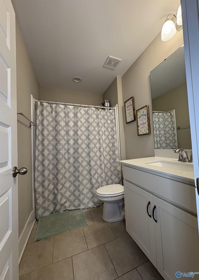 bathroom with tile patterned flooring, vanity, and toilet