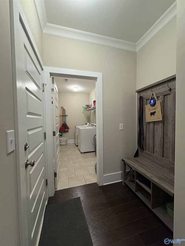 mudroom with ornamental molding, washing machine and clothes dryer, and tile patterned floors