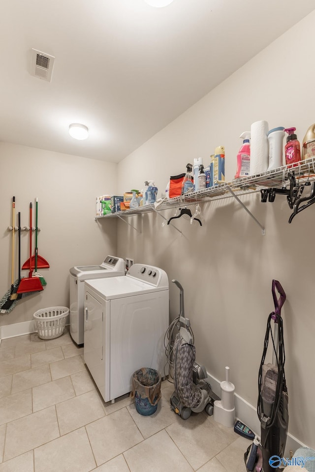 laundry area with separate washer and dryer and light tile patterned floors