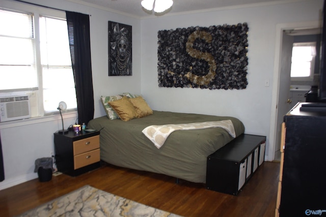 bedroom with cooling unit, dark hardwood / wood-style floors, and crown molding