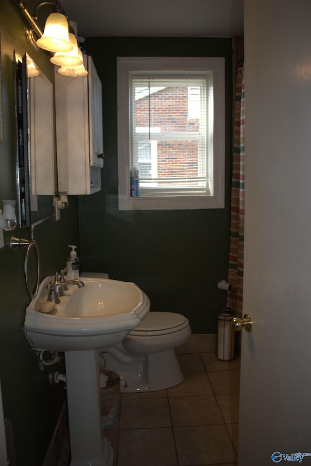 bathroom with toilet and tile patterned flooring