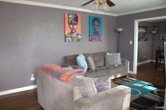 living room with a textured ceiling, dark wood-type flooring, ornamental molding, and ceiling fan