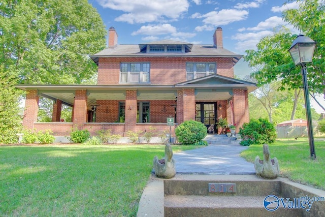 view of front facade with a porch, brick siding, a front lawn, and a chimney