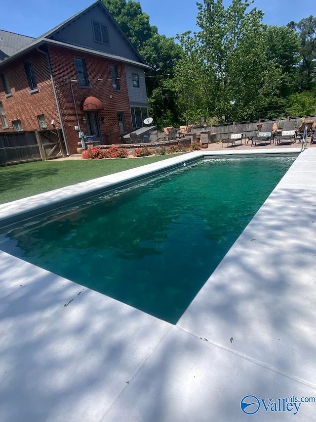 view of pool with a yard, a patio area, fence, and a fenced in pool