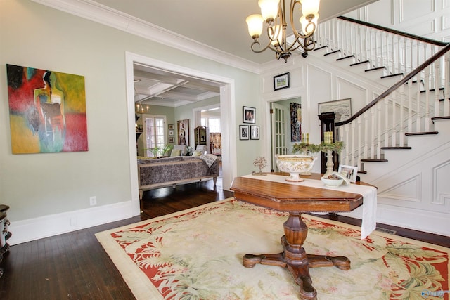 entrance foyer featuring ornamental molding, coffered ceiling, wood-type flooring, and a notable chandelier