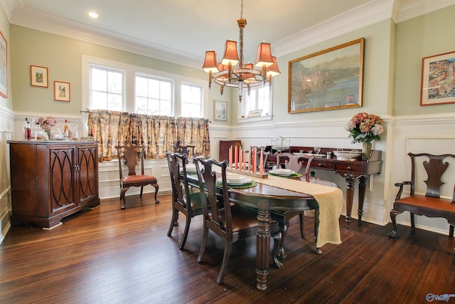 dining area with ornamental molding, wainscoting, hardwood / wood-style floors, and an inviting chandelier