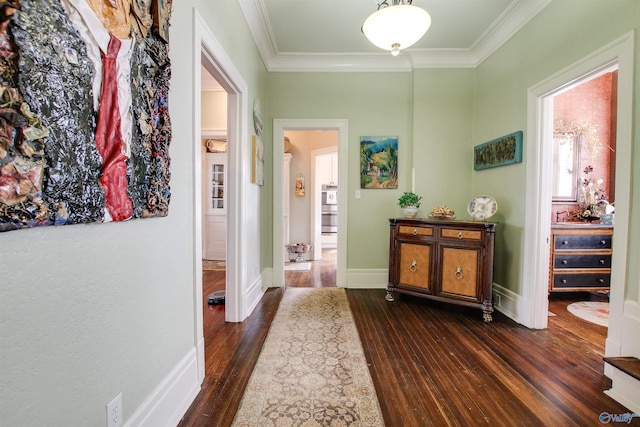 corridor with baseboards, ornamental molding, and dark wood-style flooring