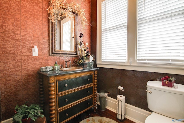 bathroom with vanity, toilet, and baseboards