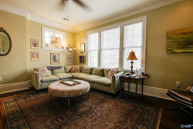 living area featuring baseboards, crown molding, and wood finished floors