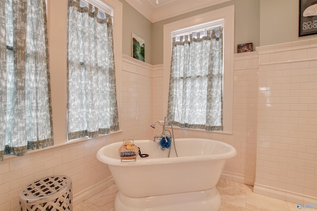 full bath with ornamental molding, tile patterned flooring, a freestanding tub, and tile walls