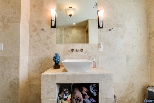 full bath featuring vanity, visible vents, and tile walls