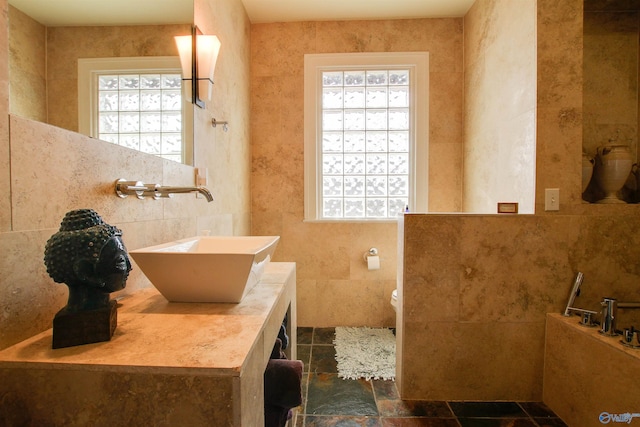 bathroom with toilet, tile walls, and vanity