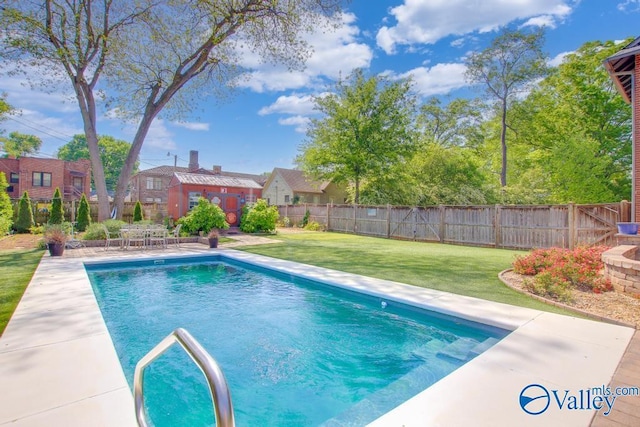 view of pool with a fenced in pool, a yard, a patio area, a fenced backyard, and an outdoor structure