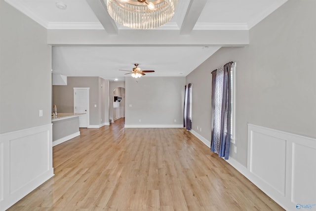 unfurnished living room featuring arched walkways, light wood-style flooring, a decorative wall, a ceiling fan, and beam ceiling