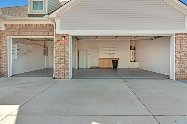 garage featuring concrete driveway and electric water heater