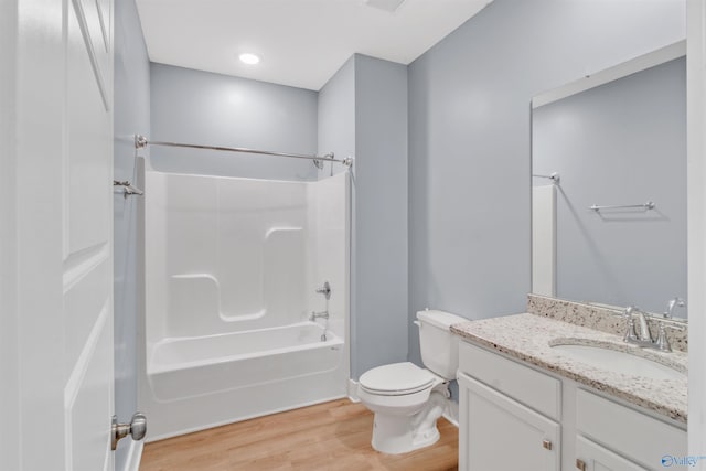 bathroom featuring toilet,  shower combination, wood finished floors, and vanity
