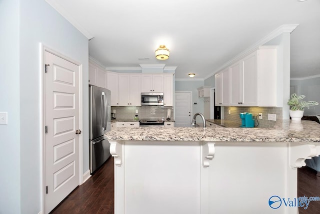119 Autumn Cove Dr, Madison, AL 35756 - kitchen with stainless steel appliances, a peninsula, decorative backsplash, crown molding, and white cabinets