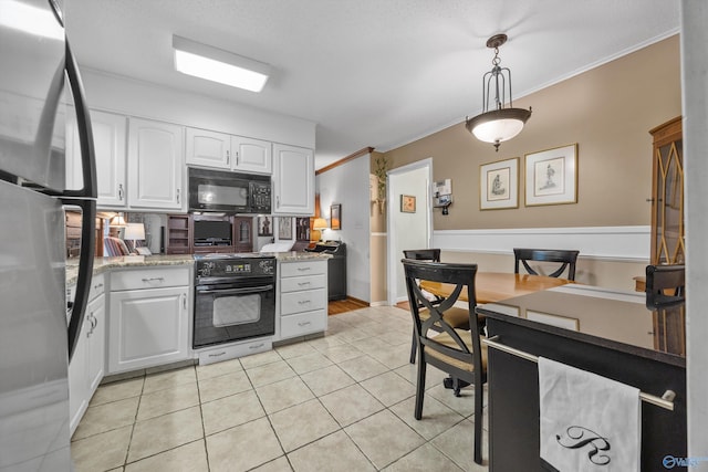 kitchen with pendant lighting, light stone counters, ornamental molding, white cabinets, and black appliances