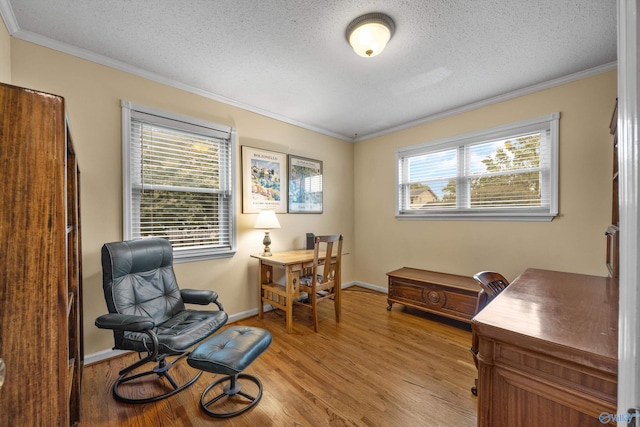 office area with light hardwood / wood-style flooring, crown molding, and a healthy amount of sunlight