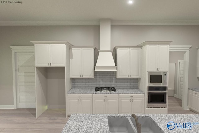 kitchen featuring light stone countertops, white cabinetry, appliances with stainless steel finishes, and decorative backsplash