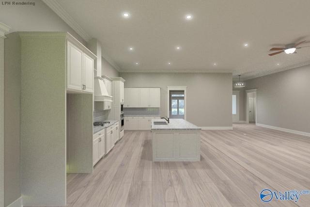 kitchen featuring white cabinetry, light stone counters, light wood-type flooring, appliances with stainless steel finishes, and a kitchen island with sink