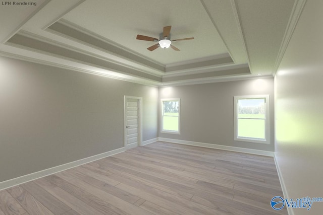 empty room featuring ornamental molding, a healthy amount of sunlight, a raised ceiling, and light hardwood / wood-style flooring