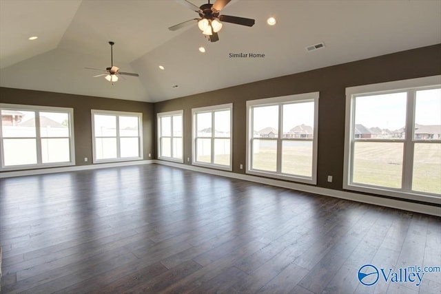 spare room featuring dark wood-type flooring, lofted ceiling, a healthy amount of sunlight, and ceiling fan