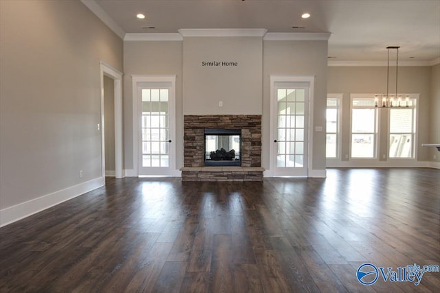 unfurnished living room with an inviting chandelier, dark wood-type flooring, a fireplace, and ornamental molding