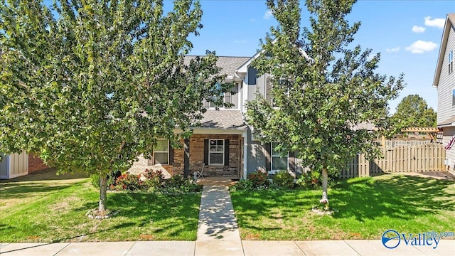 view of property hidden behind natural elements featuring a front lawn