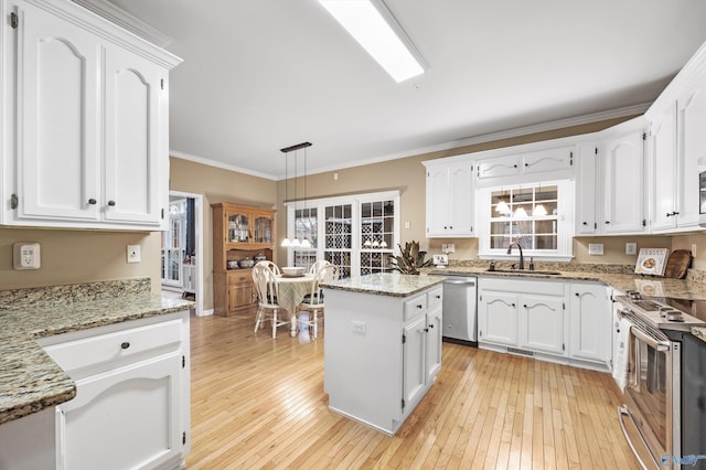 kitchen with light stone countertops, stainless steel appliances, decorative light fixtures, white cabinets, and a center island