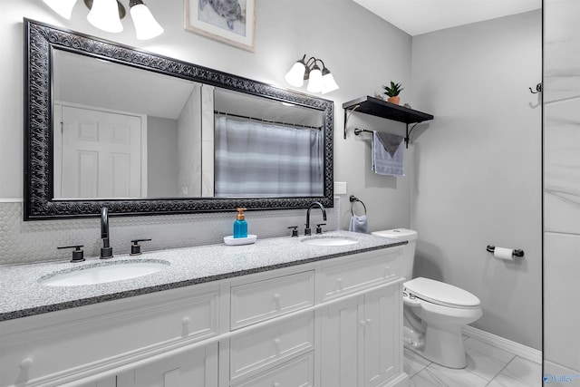 bathroom featuring double vanity, toilet, a sink, and marble finish floor
