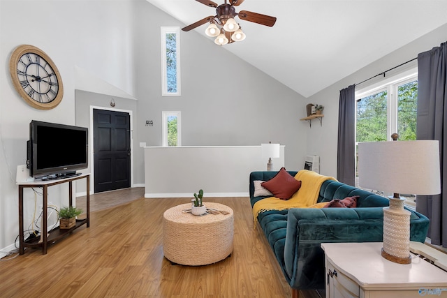 living room featuring a ceiling fan, light wood finished floors, a wealth of natural light, and high vaulted ceiling