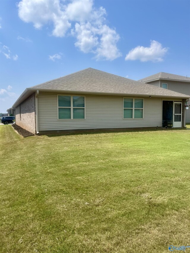 back of property featuring a lawn