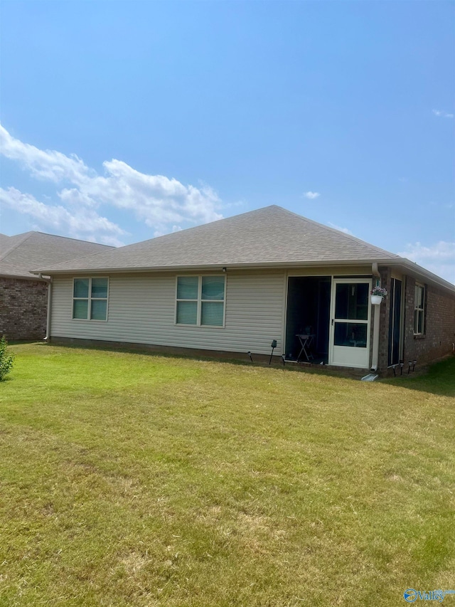 rear view of house featuring a lawn