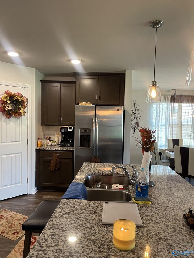 kitchen with sink, dark brown cabinets, dark hardwood / wood-style floors, tasteful backsplash, and stainless steel fridge with ice dispenser