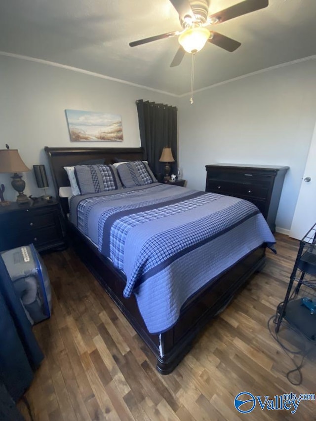 bedroom featuring dark wood-type flooring, ceiling fan, and ornamental molding