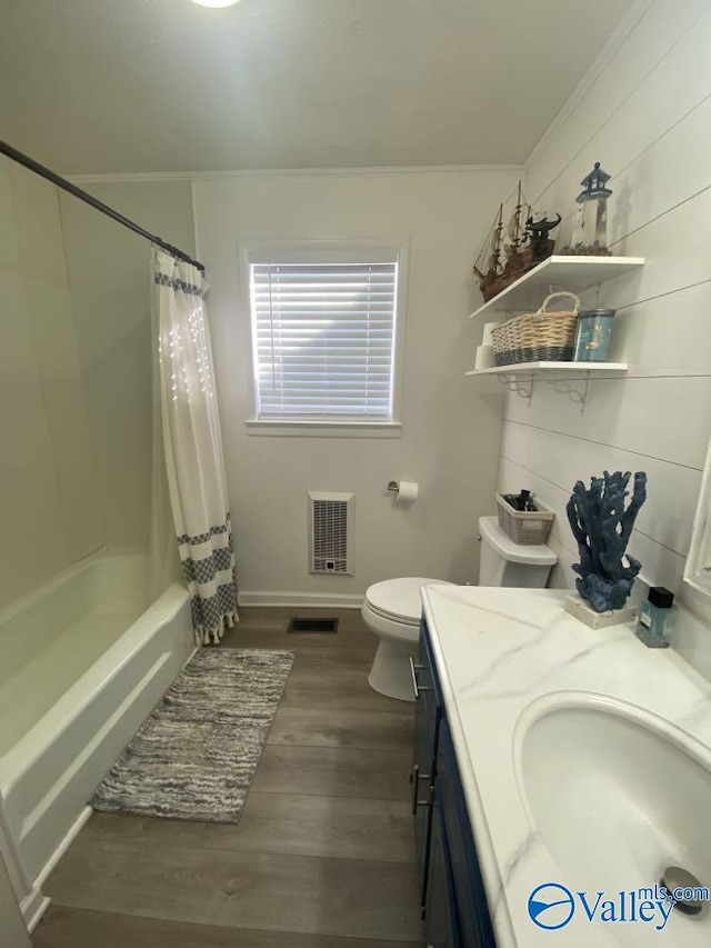 full bathroom with hardwood / wood-style floors, vanity, toilet, ornamental molding, and shower / bath combo with shower curtain