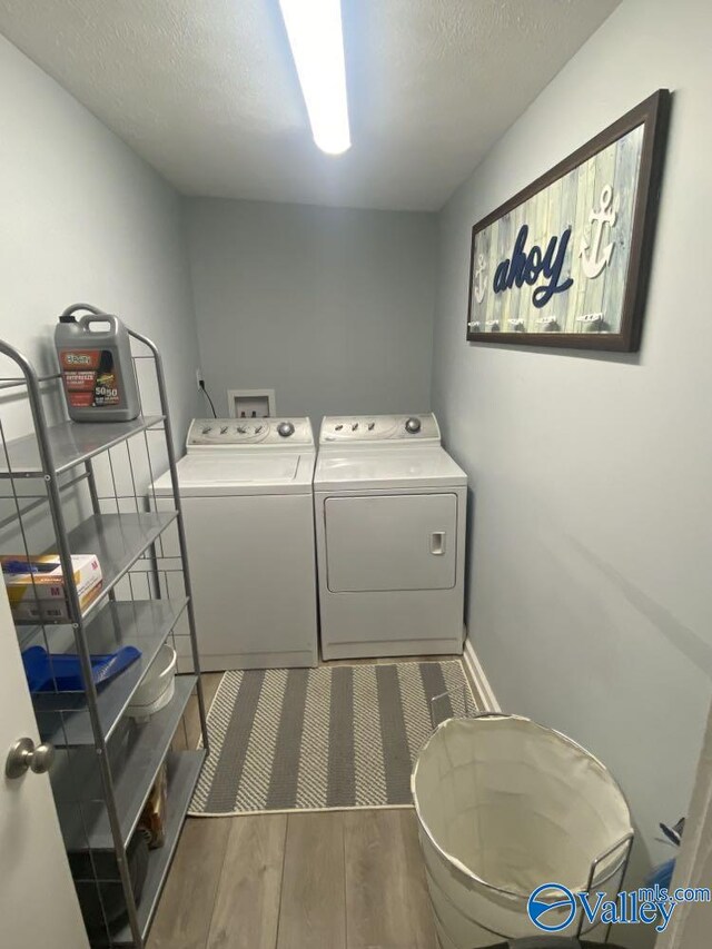 washroom featuring dark wood-type flooring, independent washer and dryer, and a textured ceiling