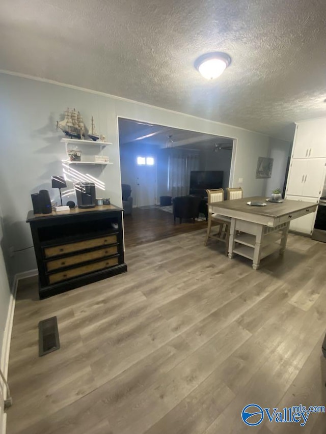 dining space with hardwood / wood-style flooring and a textured ceiling