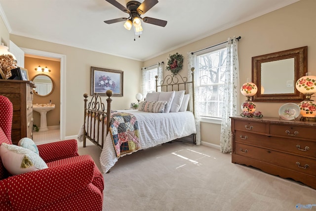 bedroom with a sink, baseboards, light carpet, and ornamental molding
