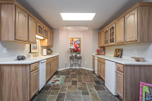 kitchen featuring glass insert cabinets, dishwasher, and stone finish flooring