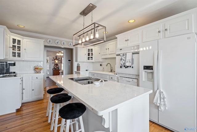 kitchen featuring a sink, white fridge with ice dispenser, white cabinets, black electric cooktop, and a chandelier