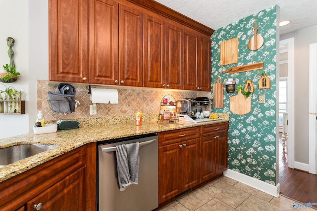 1465 Marshall Way, Southside, AL 35907 - kitchen with stainless steel dishwasher, baseboards, backsplash, light stone countertops, and brown cabinetry