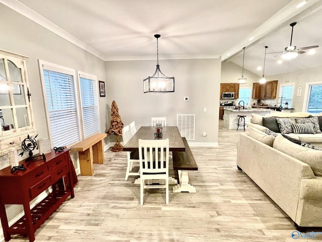 dining area featuring vaulted ceiling with beams, sink, ceiling fan with notable chandelier, and light wood-type flooring