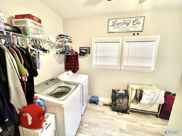 clothes washing area with light hardwood / wood-style floors and washing machine and dryer