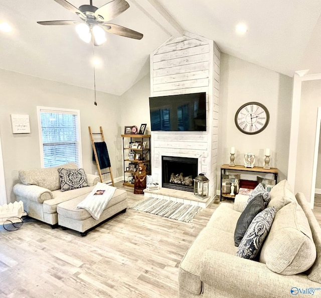 living room featuring hardwood / wood-style flooring, ceiling fan, a premium fireplace, and lofted ceiling with beams