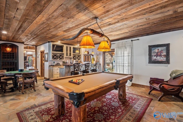 recreation room with stone tile flooring, wooden ceiling, baseboards, and a bar