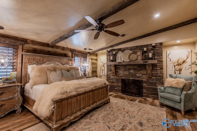 bedroom featuring vaulted ceiling with beams, wooden walls, a fireplace, and wood finished floors