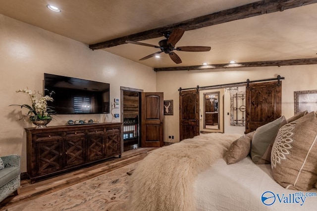 bedroom featuring a barn door, recessed lighting, wood finished floors, a ceiling fan, and beam ceiling